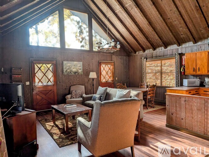 A living room with a brown chair and brown cabinetry.