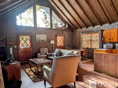 A living room with a brown chair and brown cabinetry.