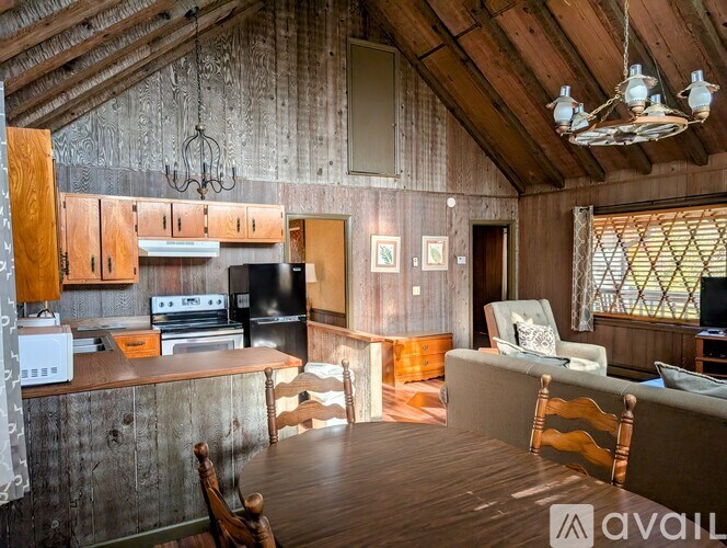 A wooden kitchen with a dining table and chairs.