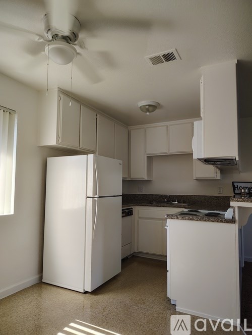 A kitchen with white appliances and cabinets.