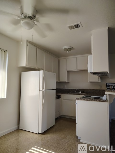A kitchen with white appliances and cabinets.