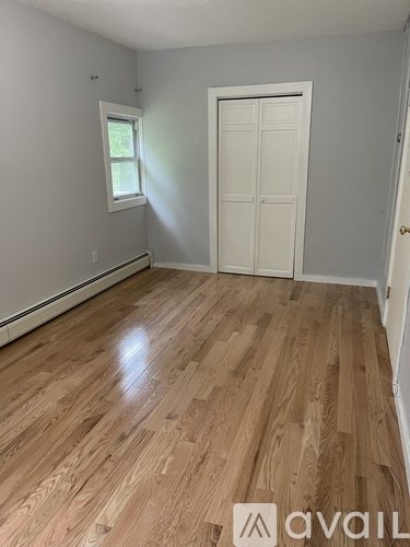 A room with wooden flooring and a white door.