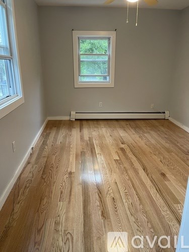A room with wooden flooring and a window.