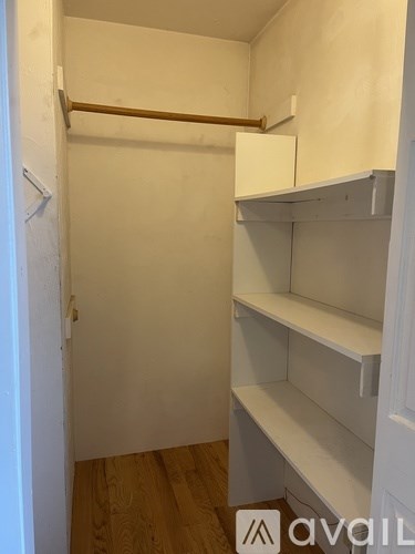 A white closet with a shelf and a hanger.