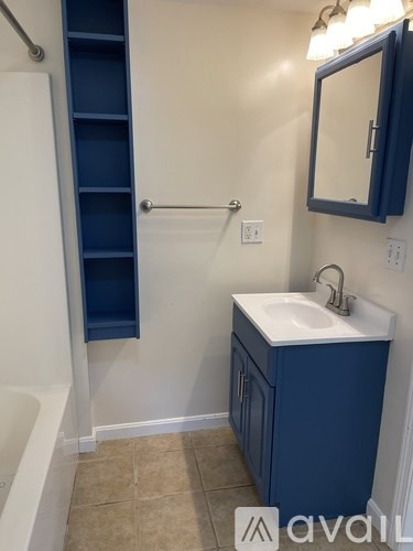 A bathroom with a blue cabinet and a white sink.