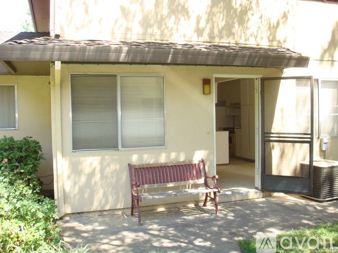 A red bench is in front of a house.