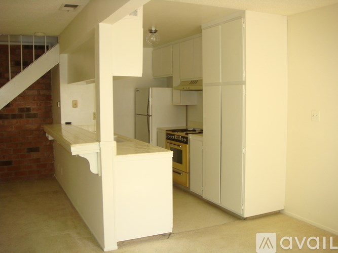 A kitchen with white cabinets and a brick wall.