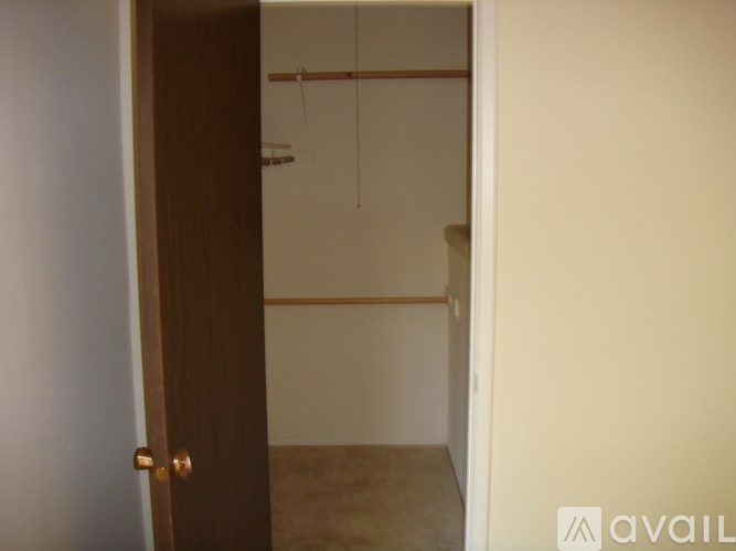 A room with a brown door and a white wall.