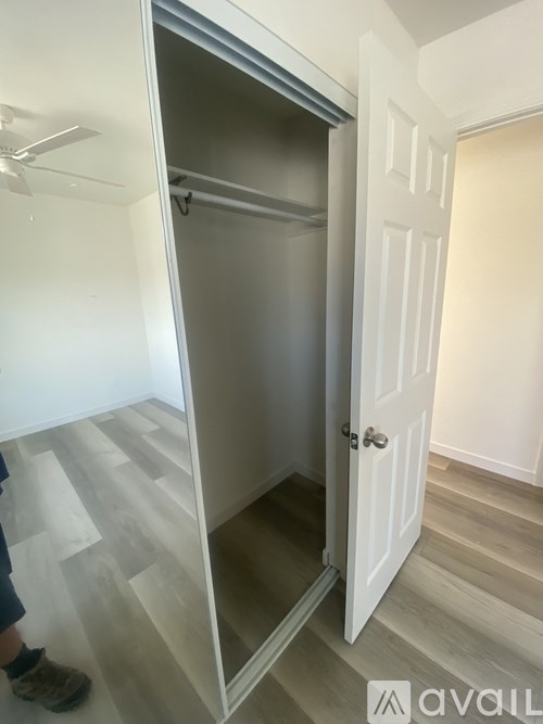 A person stands in a room with a white door and a white wall.