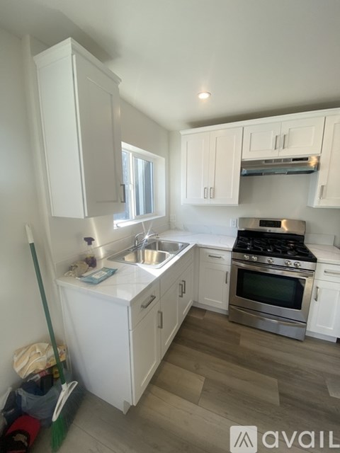A kitchen with white cabinets and a stainless steel oven.