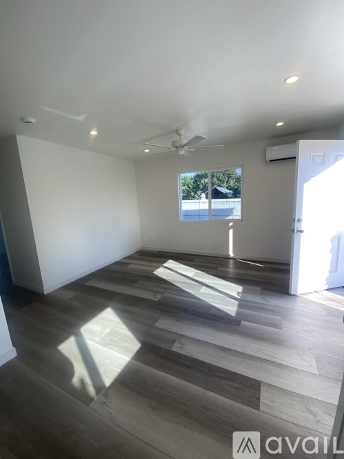 A room with wooden flooring and a ceiling fan.