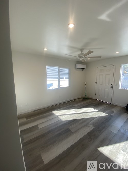 A room with a ceiling fan and wooden flooring.