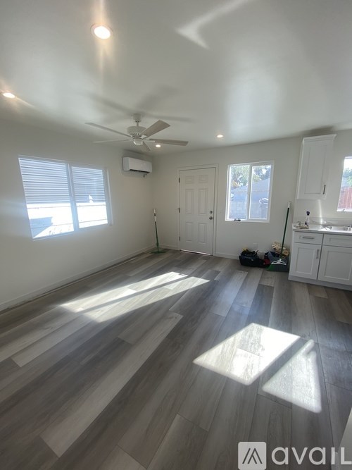 A room with a ceiling fan and wooden flooring.