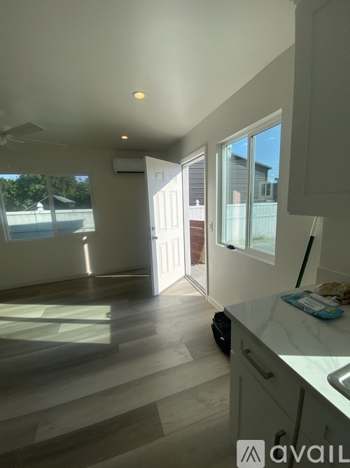 A kitchen with a marble counter top and a large window.