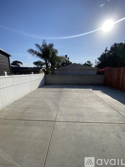A sunny day with a clear blue sky and a concrete pathway.
