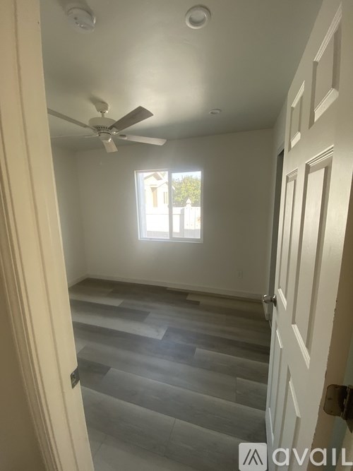 A room with a ceiling fan and a window.