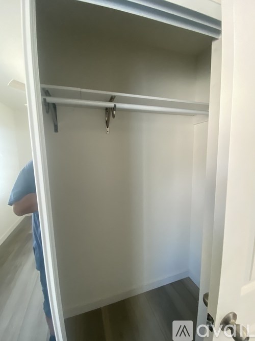A white closet with a hanger on the rail.