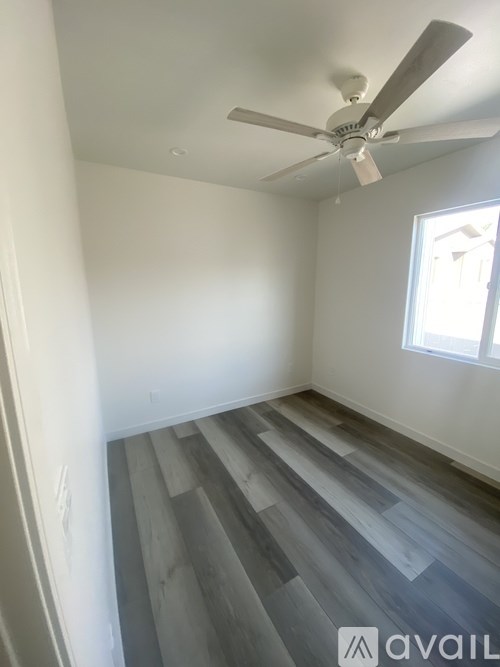 A room with a fan and a window.