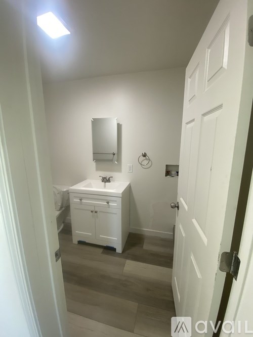 A bathroom with a sink, mirror, and toiletries.