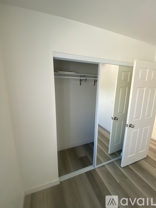A white door is open to a small closet with a shelf.