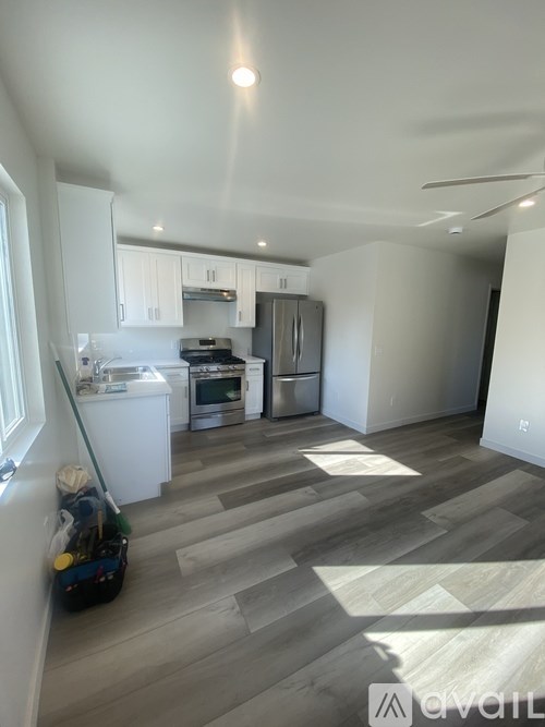 A kitchen with a refrigerator, oven, and sink.