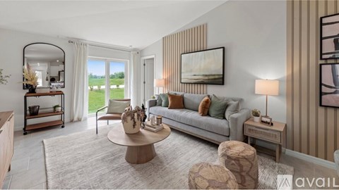 A living room with a grey sofa, a round coffee table, and a large painting on the wall.