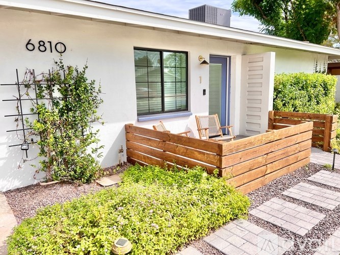 A white house with a number 6810 on the wall.