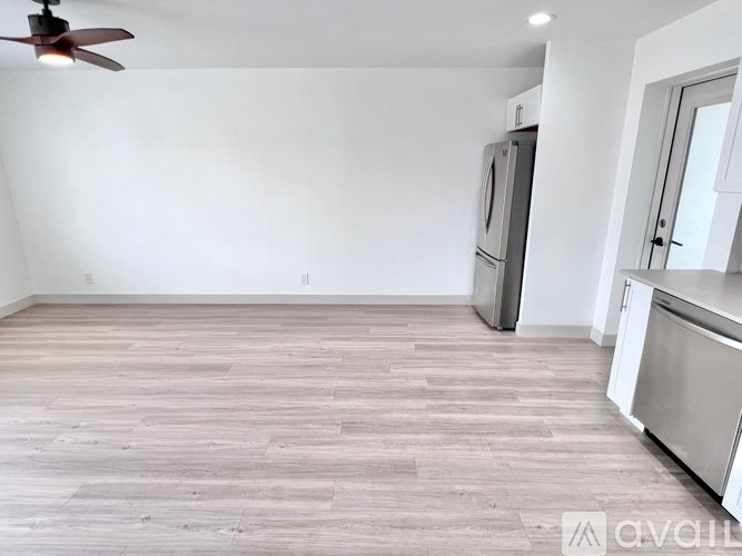 A kitchen with a refrigerator, microwave, and oven is shown.