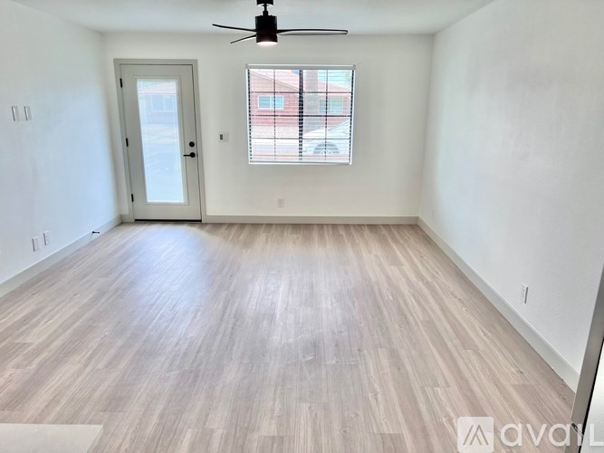 A room with a ceiling fan and a window with blinds.