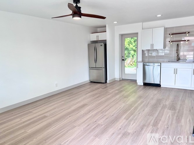 A spacious kitchen with a refrigerator, oven, and cabinets.