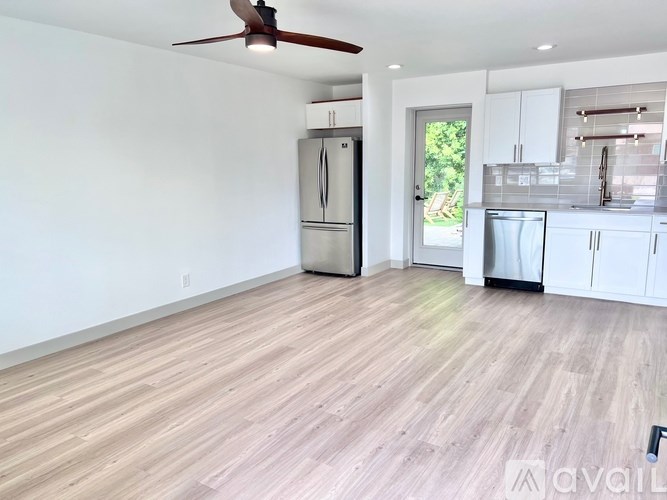 A kitchen with a refrigerator, sink, and cabinets is available for rent.