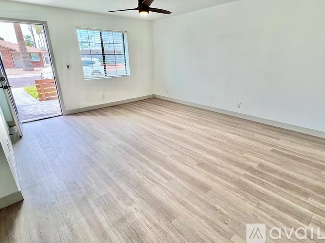 A room with wooden flooring and a ceiling fan.