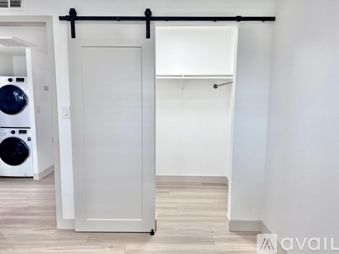 A white door with a black handle is in a room with a washing machine.