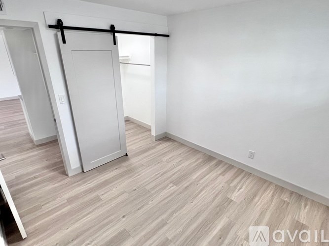 A room with a sliding door and wooden flooring.