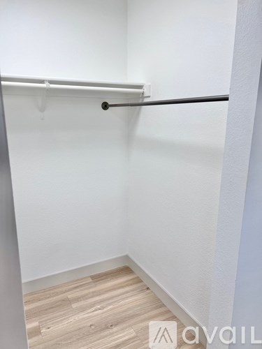 A white wall with a black bar and a wooden floor.