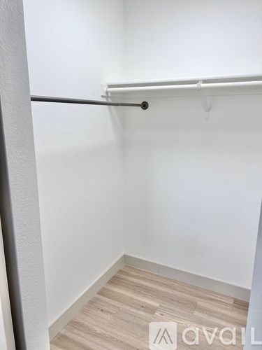 A white wall with a wooden floor and a metal rod.