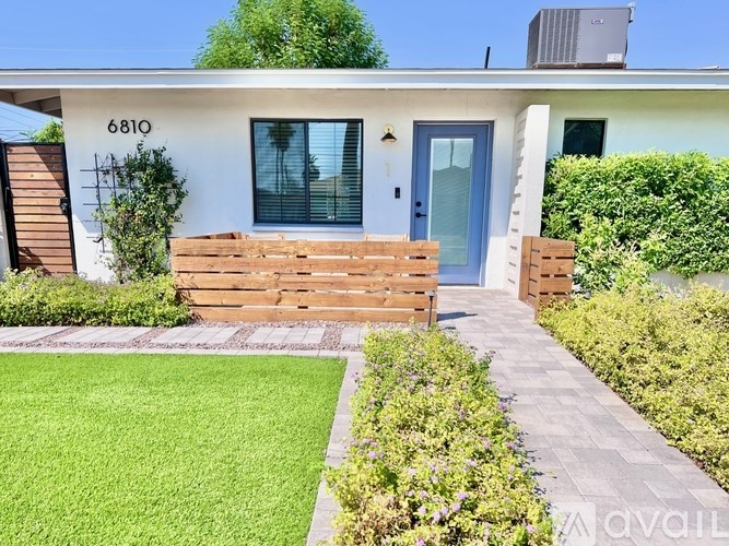 A house numbered 6810 with a blue door and a small front yard.
