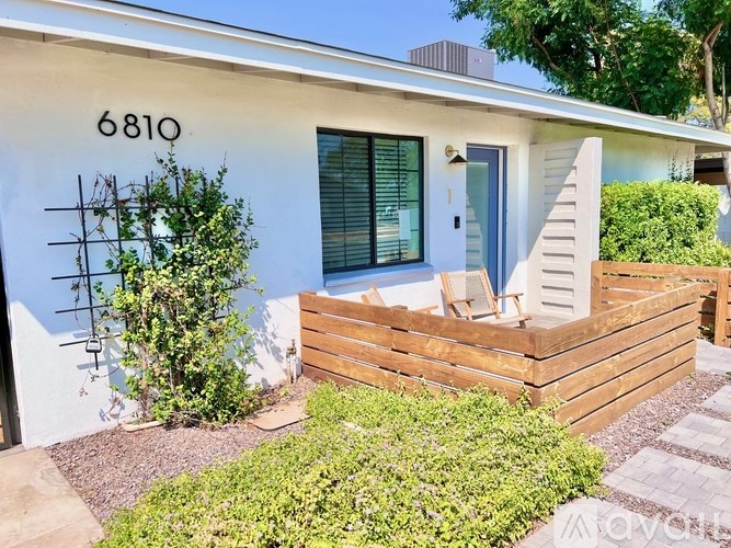 A white house with the number 6810 on the wall.