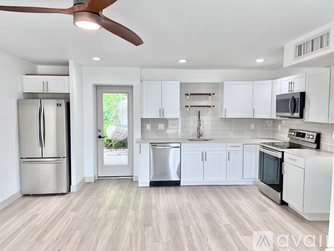 A modern kitchen with white cabinets and stainless steel appliances.