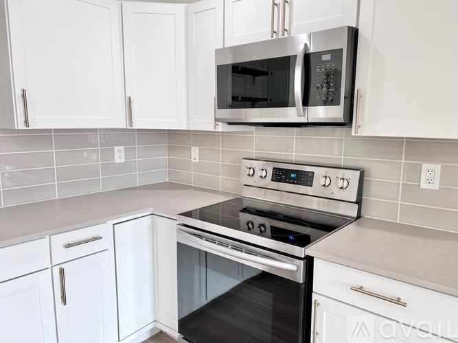 A modern kitchen with white cabinets and a stainless steel oven.