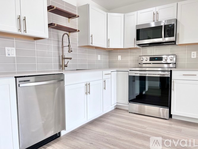 A kitchen with white cabinets and a stainless steel oven.