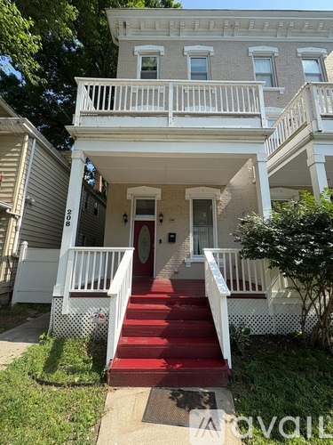 A white two-story house with a red staircase.