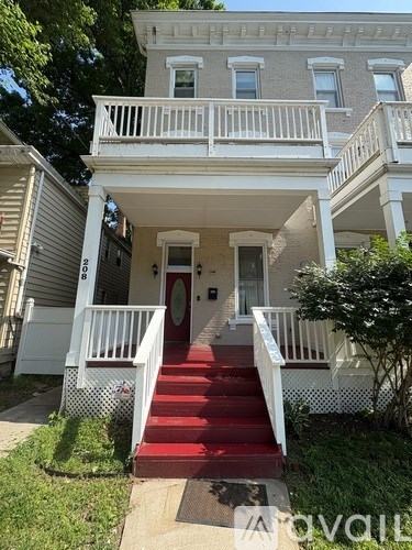 A white two-story house with a red staircase.