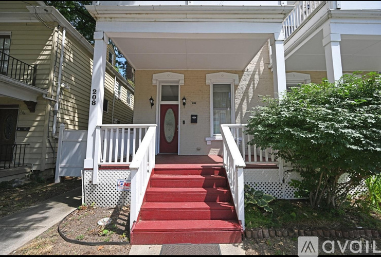 A house with a red carpeted stairway leading to the front door.