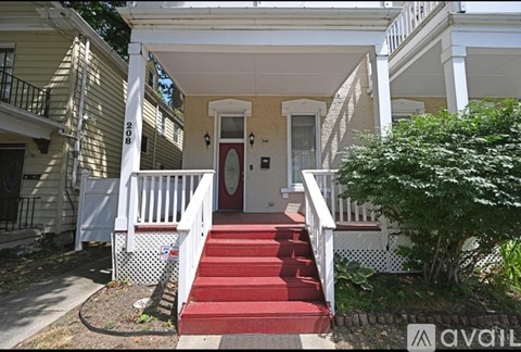 A house with a red carpeted stairway leading to the front door.