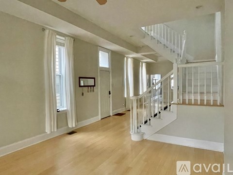 A spacious room with a staircase and a window.