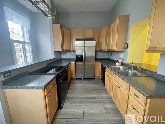 A kitchen with wooden cabinets and a black countertop.