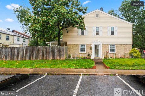 A two-story house with a white front door and a porch.