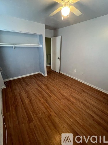 A room with wooden flooring and a ceiling fan.