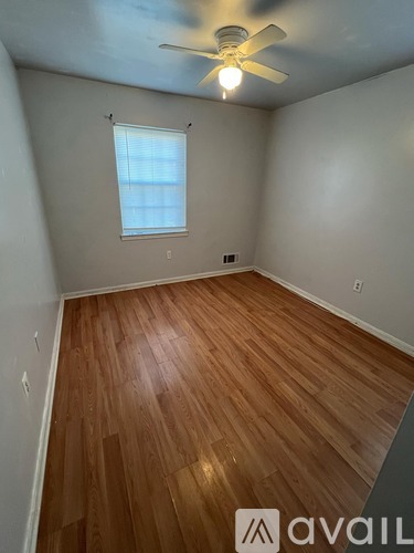 A room with wooden flooring and a ceiling fan.